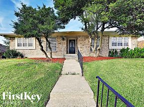 Garland house for rent - A house with a red front yard and a black railing.
