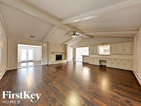 Garland house for rent - A spacious room with wooden floors and a fireplace.