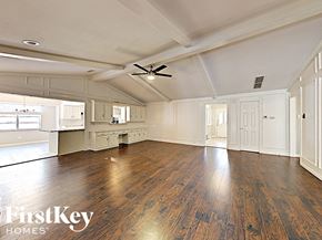 Garland house for rent - A spacious room with wooden floors and a ceiling fan.