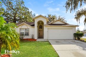 Winter Haven house for rent - a white house with a driveway and a tree