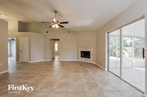Winter Haven house for rent - an empty living room with a fireplace and a ceiling fan