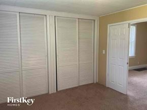 Cincinnati house for rent - an empty bedroom with three closet doors and a door to the bathroom