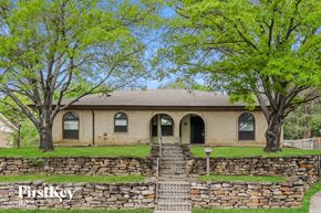North Richland Hills house for rent - A house with a stone wall in front of it.