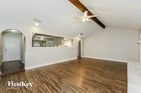 North Richland Hills house for rent - A spacious room with wooden flooring and a ceiling fan.