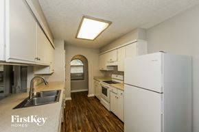 North Richland Hills house for rent - A kitchen with a white fridge and wooden floors.