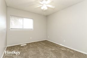 Arlington house for rent - the spacious bedroom of this manufactured home has a carpeted floor and a window
