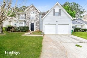 Decatur house for rent - a white house with a white garage door in front of a green yard