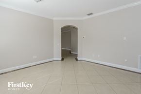 Land O'lakes house for rent - an empty living room with tiled flooring and a door to the hallway