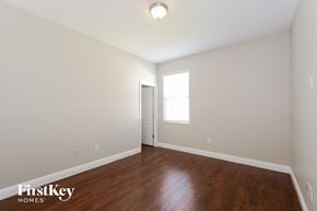 Land O'lakes house for rent - a bedroom with white walls and wood flooring and a window
