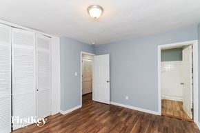 Decatur house for rent - a bedroom with blue walls and white closet doors and a hard wood floor