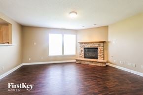 Indianapolis house for rent - A spacious living room with a fireplace and wooden floors.