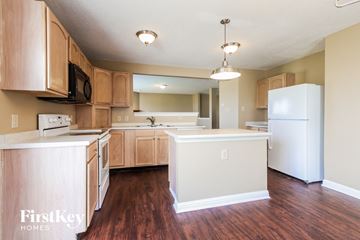 Indianapolis house for rent - A kitchen with wooden cabinets and a white fridge.