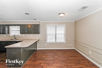 Bartlett house for rent - A kitchen with a wooden floor and a window with white blinds.
