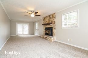 Conyers house for rent - A spacious living room with a fireplace and a ceiling fan.