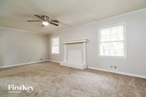 Conyers house for rent - A spacious room with a fireplace and a ceiling fan.