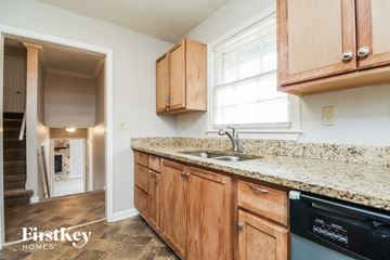 Conyers house for rent - A kitchen with wooden cabinets and granite countertops.