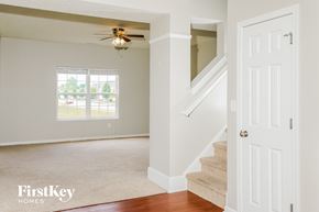 Greenwood house for rent - an empty living room with stairs and a ceiling fan