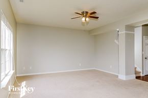 Greenwood house for rent - a empty living room with a ceiling fan