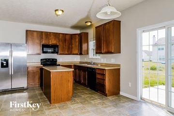 Greenwood house for rent - a kitchen with wooden cabinets and stainless steel appliances