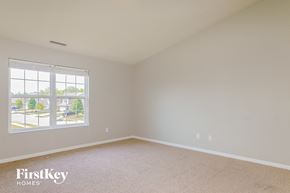Greenwood house for rent - a bedroom with a large window and beige carpet