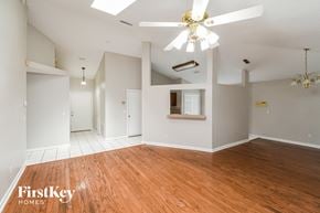 Jacksonville house for rent - an empty living room with wood floors and a ceiling fan