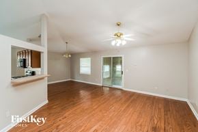Jacksonville house for rent - an empty living room with wood floors and a ceiling fan