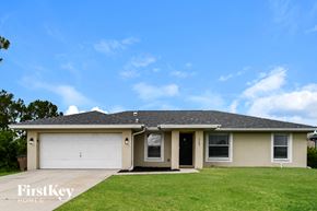 Lehigh Acres house for rent - A house with a garage and a driveway is for sale.