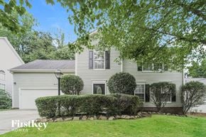 Charlotte house for rent - a white house with a lawn and bushes in front of it