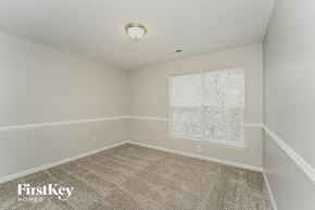 Charlotte house for rent - the bedroom of a home with a carpeted floor and a window