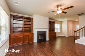 Mcdonough house for rent - an empty living room with a ceiling fan and a fireplace