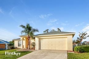 Lakeland house for rent - a yellow house with a garage door and a palm tree