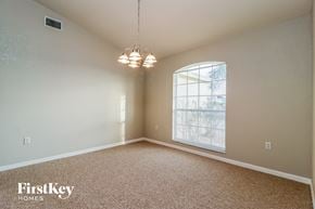Lakeland house for rent - an empty dining room with a large window and a chandelier