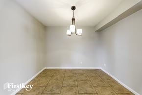 Phoenix house for rent - a empty dining room with tile floors and a chandelier