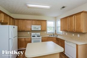 Kennesaw house for rent - A kitchen with wooden cabinets and a white fridge.