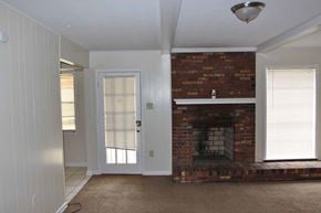 Memphis house for rent - an empty living room with a brick fireplace