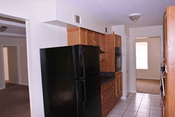 Memphis house for rent - a kitchen with a black refrigerator and wooden cabinets