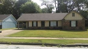 Memphis house for rent - the front of a brick house with a lawn and a sidewalk
