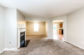 Indianapolis house for rent - A spacious living room with a fireplace and carpeted floor.