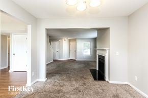 Indianapolis house for rent - A spacious living room with a fireplace and a carpeted floor.