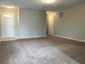 Indianapolis house for rent - an empty living room with carpet and a door