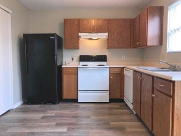 Indianapolis house for rent - a kitchen with white appliances and wooden cabinets
