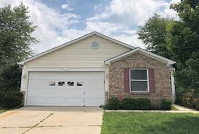 Indianapolis house for rent - a home with a white garage door and a brick house