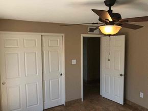 Phoenix house for rent - a bedroom with a ceiling fan and two doors and a closet