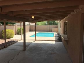 Phoenix house for rent - a backyard with a swimming pool and a covered patio