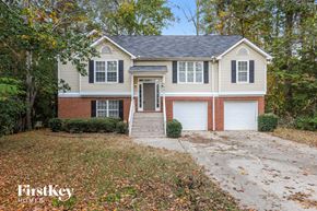Powder Springs house for rent - front view of a white house with two garage doors and a driveway