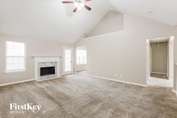 Powder Springs house for rent - a spacious living room with carpet and a fireplace