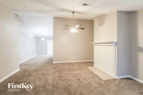Gainesville house for rent - an empty living room with a ceiling fan