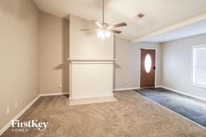 Gainesville house for rent - a empty living room with a ceiling fan and a door