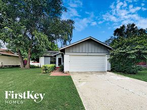 Florissant house for rent - a small white house with a driveway and a garage door
