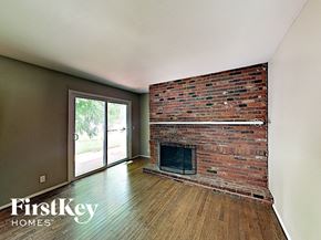 Florissant house for rent - the living room has a brick fireplace and wood flooring